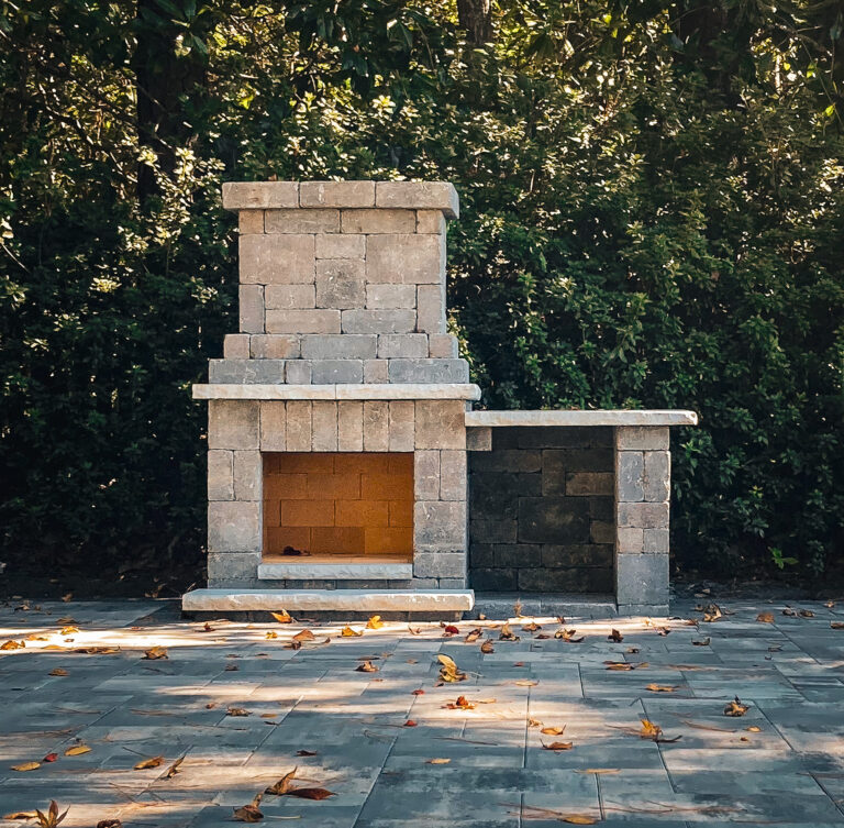 Custom-built outdoor fireplace with a stone surround, perfect for luxury backyard gatherings and cozy evenings.